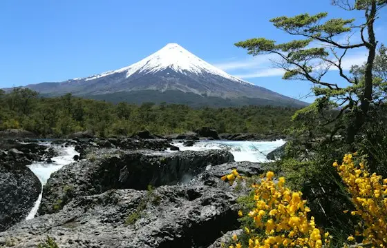 Cascada y río con volcán nevado al fondo